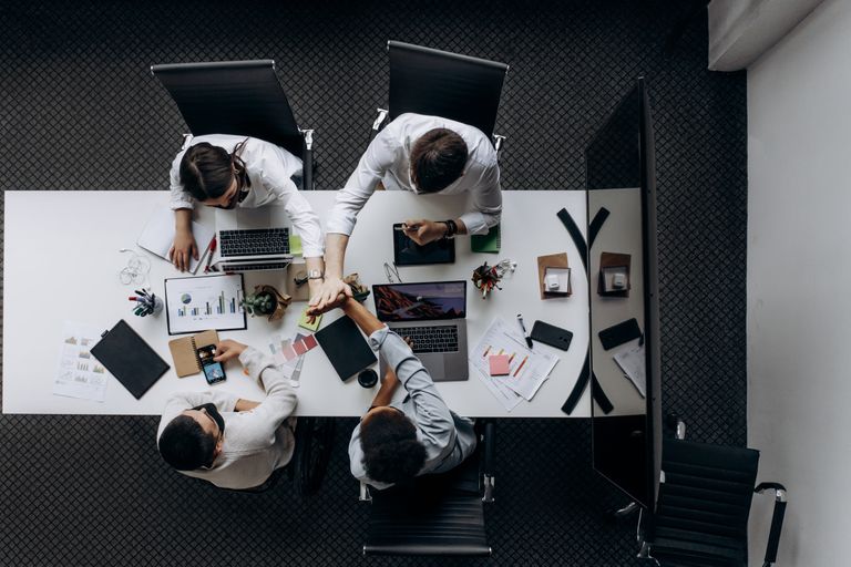 High angle view of colleagues collaborating around a conference table in a modern office setting.