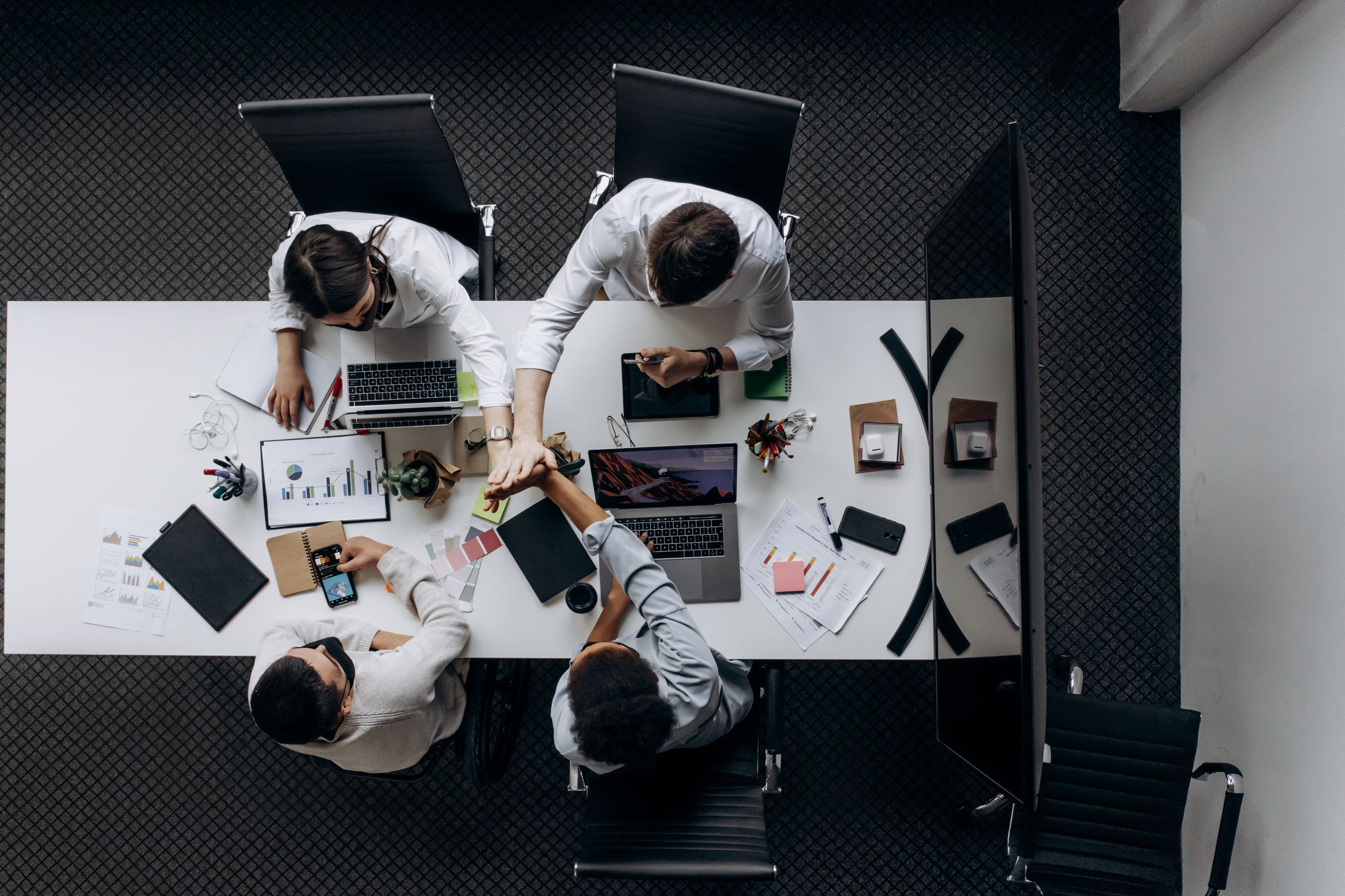 High angle view of colleagues collaborating around a conference table in a modern office setting.